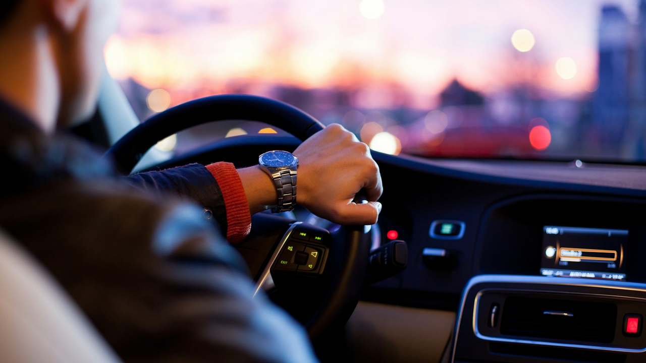 Driver behind the wheel at dusk shopping for auto coverage